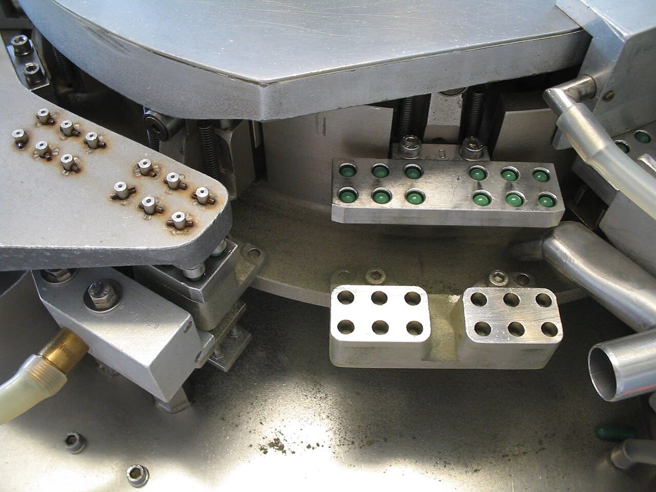 Close-up of the dosing and capsule segments of a capsule filling machine